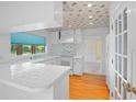 Well-lit kitchen featuring white cabinetry, tiled countertops, and a sunny window, great for cooking at 102 Old Hickory, Longwood, FL 32750