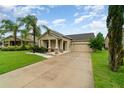 Inviting single-Gathering home with a well-maintained lawn, complemented by lush palm trees and an attached garage at 1089 Seburn Rd, Apopka, FL 32703