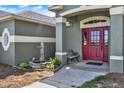 Inviting front entry with a red door, charming fountain, and bench seating at 11115 Romance Ct, Winter Garden, FL 34787