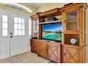 Cozy living room showcasing a wooden entertainment center and front door access at 11115 Romance Ct, Winter Garden, FL 34787