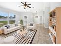 Bright living room with striped rug, ceiling fan, modern furniture, and natural light at 120 Marion Oaks Mnr, Ocala, FL 34473