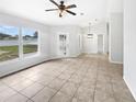 Spacious and airy living room with neutral tones, tile flooring, and large windows at 120 Marion Oaks Mnr, Ocala, FL 34473
