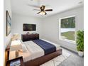 Well-lit main bedroom featuring a TV, dark wood furniture, and a white rug at 120 Marion Oaks Mnr, Ocala, FL 34473