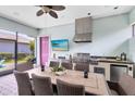 Covered outdoor kitchen and dining area with stainless steel grill and woven furniture at 13701 Chauvin Ave, Orlando, FL 32827