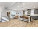 An open kitchen with stainless steel appliances, a breakfast bar, and gray cabinetry at 15358 Arcadia Bluff Loop, Winter Garden, FL 34787