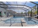 Relaxing screened-in pool area with a slide, a waterfall, and a hot tub, perfect for outdoor enjoyment at 15378 Gilligan Ct, Winter Garden, FL 34787