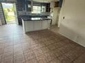 View of an eat-in kitchen with an island, stylish flooring, and a window at 1675 Louis Dr, Kissimmee, FL 34758