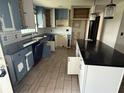 Kitchen with stylish tile flooring, an island, dark countertops and light blue and white cabinets at 1675 Louis Dr, Kissimmee, FL 34758