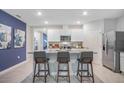 Modern kitchen with a granite island, seating for three, stainless steel appliances, and white cabinetry at 1830 Escobar Ave, Deltona, FL 32725