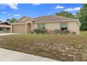Charming single-story home with a two-car garage and well-maintained lawn at 2104 E Parkton Dr, Deltona, FL 32725