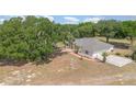 Aerial view showcasing the home's spacious yard, patio area, and surrounding mature trees at 22619 State Road 44, Eustis, FL 32736