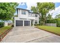 Charming two-story home boasts a modern design, manicured lawn, and a spacious driveway leading to the two-car garage at 2407 Lafayette Ave, Winter Park, FL 32789
