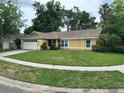 Attractive yellow single-Gathering home with a manicured lawn and a two car garage at 243 Country Landing Blvd, Apopka, FL 32703