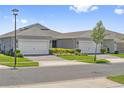 Home exterior view featuring two-car garage, manicured lawn, and appealing neighborhood landscape at 2960 Cherry Blossom Loop, St Cloud, FL 34771