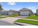 Exterior showcasing the home's garages, tidy front lawns, and the appealing neighborhood at 2960 Cherry Blossom Loop, St Cloud, FL 34771