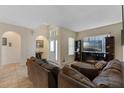 Cozy living room features tile flooring, with modern entertainment center and comfortable seating at 322 Huron Dr, Kissimmee, FL 34759