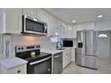 Modern kitchen features stainless steel appliances, white cabinetry, and quartz countertops at 326 Hobart Ave, Daytona Beach, FL 32114