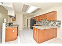 Bright kitchen featuring tile flooring, granite countertops, and modern black appliances at 345 Feather Pl, Longwood, FL 32779