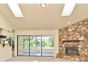 Inviting living room features a stone fireplace, skylights, and sliding glass doors to the outdoor patio at 345 Feather Pl, Longwood, FL 32779