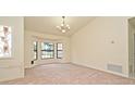 Large, sunlit living area with chandelier lighting and views of the front yard at 345 Feather Pl, Longwood, FL 32779