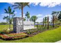 Charming Thompson Village community sign featuring stone pillar, colorful flower bed and well-manicured lawn at 350 Thompson Village Ave, Apopka, FL 32703