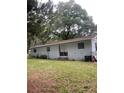 Back exterior view featuring a sliding glass door leading to the spacious backyard area at 3600 Ne 22Nd Ct, Ocala, FL 34479