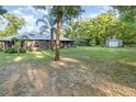 Spacious backyard featuring a screened-in lanai, storage shed, and mature trees at 433 Tangerine Ave, Lake Helen, FL 32744