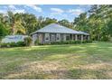 Attractive single-story home with stone accents, metal roof, and green lawn at 433 Tangerine Ave, Lake Helen, FL 32744