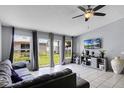 Open living area with large windows, neutral tile flooring, and a ceiling fan for comfortable living at 460 Flamingo Ct, Kissimmee, FL 34759