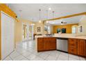 Bright, open kitchen featuring wood cabinets, a neutral countertop, and a door to the outdoor area at 507 Westwind Dr, Davenport, FL 33896