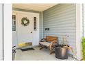 Inviting front porch featuring a decorative wreath, bench, and potted plant accents at 5395 Dover Village Ln # 305, Orlando, FL 32812