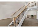 Carpeted staircase with wood railing leads to the upper level of the home at 5395 Dover Village Ln # 305, Orlando, FL 32812