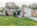 Inviting brick home featuring a covered entryway, manicured lawn, and lush landscaping at 635 San Lanta Cir, Sanford, FL 32771