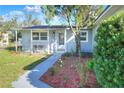 Cozy home entrance featuring a charming porch with seating, lush landscaping, and a freshly painted exterior at 642 Carver Dr, Lake Wales, FL 33853