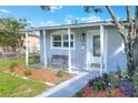 Close up of a cozy covered porch, showing a charming seating area, and meticulous landscaping at 642 Carver Dr, Lake Wales, FL 33853