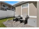 Cozy back patio area with two chairs, a small table, privacy fence and exterior storage unit at 725 N Grandview Ave, Daytona Beach, FL 32118