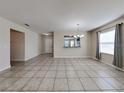 Open dining room with tile flooring, a window, and view into the kitchen at 7806 Tanbier Dr, Orlando, FL 32818
