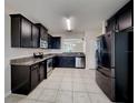 Modern kitchen with stainless steel appliances, dark cabinets, and granite countertops at 7806 Tanbier Dr, Orlando, FL 32818