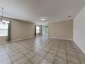 Bright, open living room with tile flooring and sliding door access to the backyard at 7806 Tanbier Dr, Orlando, FL 32818