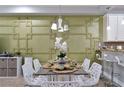 Dining area with an ornate decorative wall, designer light fixture and seating for six at 8122 Roseville Rd, Davenport, FL 33896