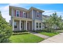 Charming two-story home with pink shutters, a covered front porch, and a well-maintained lawn at 8226 Nemours Pkwy, Orlando, FL 32827