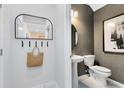 Charming powder room with gray wallpaper, decorative mirror, and pedestal sink at 11352 Blue Bay Dr, Orlando, FL 32832