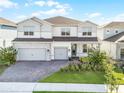Beautiful two-story home with a three-car garage, brick driveway, and manicured landscaping at 13758 Tybee Beach Ln, Orlando, FL 32827