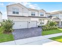 Attractive two-story home with a three-car garage, brick driveway, and well-kept front yard at 13758 Tybee Beach Ln, Orlando, FL 32827