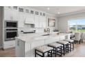 Bright kitchen features stainless steel appliances, white cabinetry, large island with seating, and plenty of counter space at 13758 Tybee Beach Ln, Orlando, FL 32827