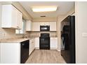 Updated kitchen with white cabinets, black appliances, and light countertops at 1515 Pelican St, Longwood, FL 32750