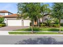 A view of the house with a brick driveway and walkway, with trees providing shade from the street at 16696 Otterchase Ln, Winter Garden, FL 34787