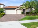 Beautiful home exterior featuring a well-manicured lawn and an elegant brick driveway at 16696 Otterchase Ln, Winter Garden, FL 34787