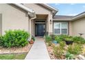 Inviting front entrance with a black door, attractive landscaping, and a walkway leading to the home at 186 Nw 44Th St, Ocala, FL 34475