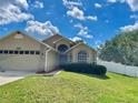 Charming one-story home featuring a two-car garage, brick accents, and a well-manicured lawn at 1980 Aquarius Ct, Oviedo, FL 32766